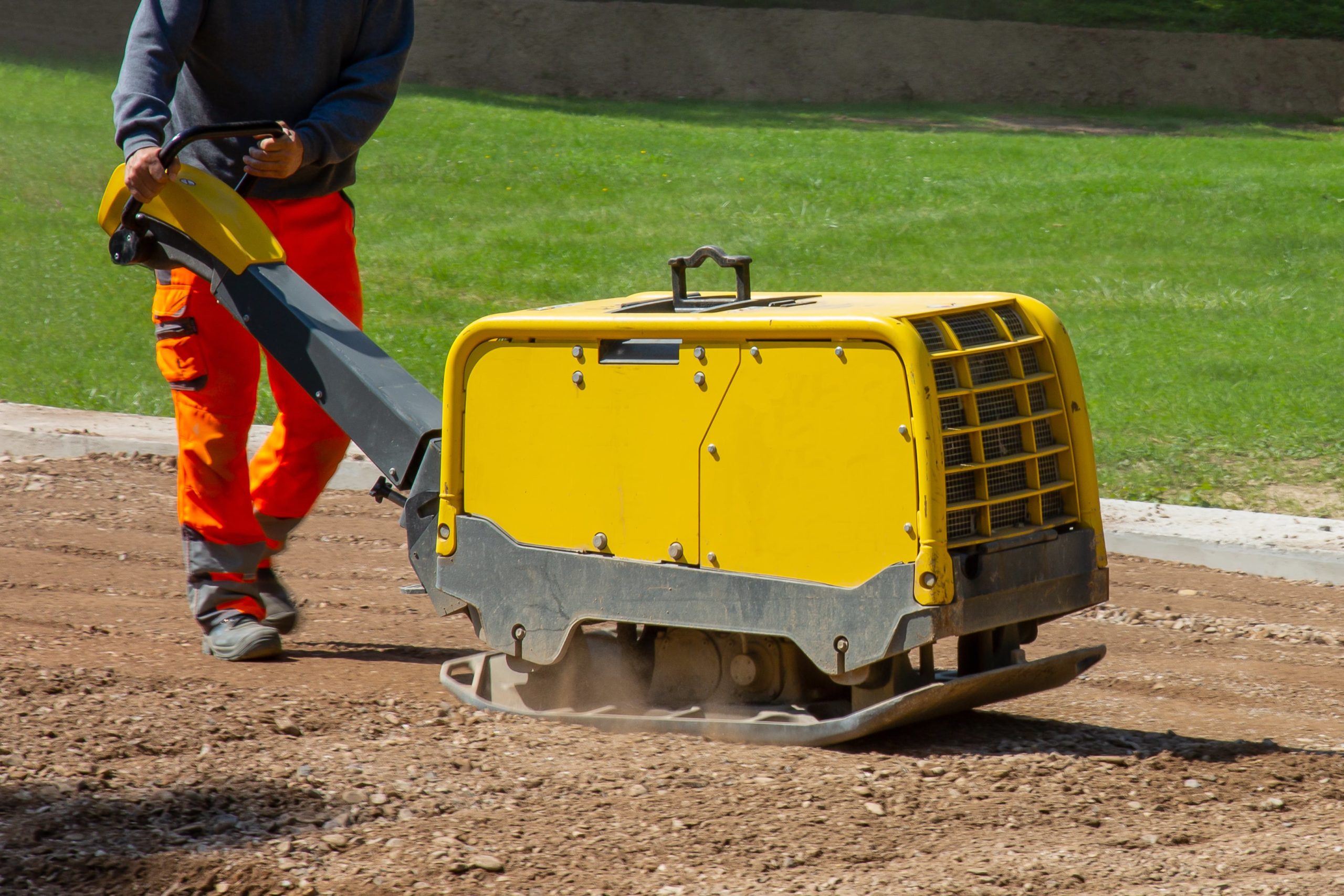 construction-worker-working-road-with-vibratory-plate-min
